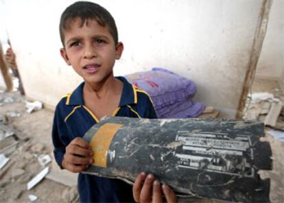 Un niño muestra un trozo de misil entre las ruinas de su casa en Gaza, atacada ayer por la aviación israelí.