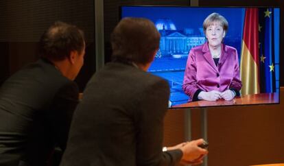 Funcionarios alemanes miran el vídeo del mensaje de Merkel.