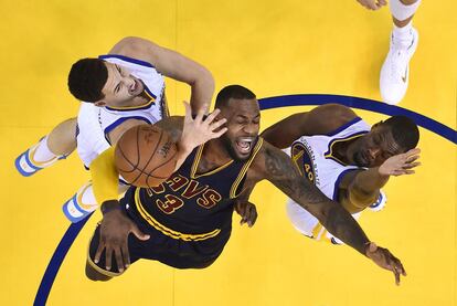 LeBron James, en el centro, pierde la pelota entre Klay Thompson, izquierda, y Harrison Barnes