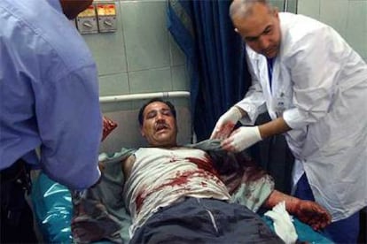 Varios médicos atienden a un iraquí herido en el atentado de la carretera que une Bagdad con el aeropuerto.