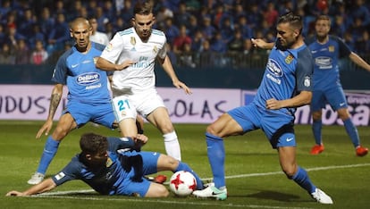 Mayoral rodeado de tres jugadores del Fuenlabrada. 