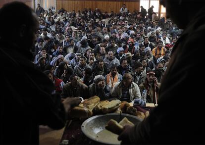 Un grupo de refugiados egipcios, acogido en un campamento improvisado en la casa de cultura de Ben Guerdan, espera el reparto de comida.