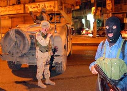 Un soldado estadounidense y un policía iraquí (cubierto) patrullan en el centro de Mosul el viernes por la noche.