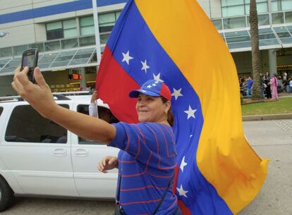 Cira Rodríguez, venezolana residente en Miami (Estados Unidos), se fotografía con la bandera de su país mientras espera para votar en Nueva Orleans, adonde han viajado cientos de compatriotas tras el cierre del consulado en la ciudad de Florida.
