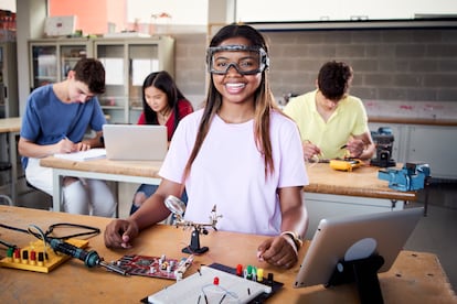 Una estudiante de Formación Profesional con gafas de seguridad sonríe en un momento de su clase.