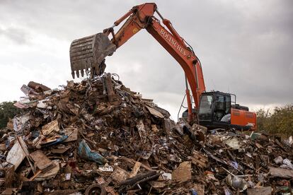 Una excavadora trabaja en la pila de escombros que los vecinos han retirado de sus casas, este jueves en Aldaia.