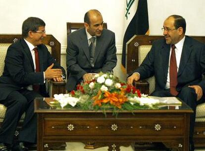El primer ministro iraquí, Nuri al Maliki (d) conversa con el ministro de Exteriores turco, Ahmed Davutoglue, hoy en Bagdad