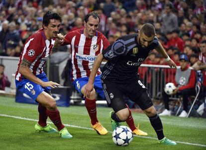 Benzema (derecha) presionado por Diego Godin (centro) y Stefan Savic.