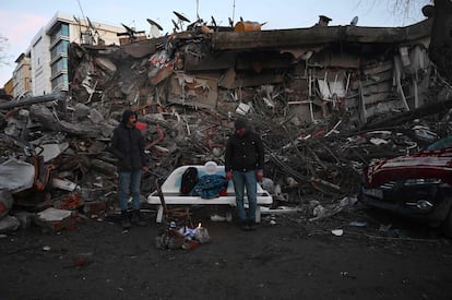 Dos hombres, junto a los escombros de un edificio colapsado en Kahramanmaras (Turquía). 