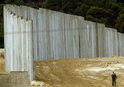 Un palestino camina junto al muro israelí ayer en el tramo que separa Jerusalén de Cisjordania.