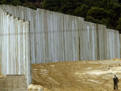 Un palestino camina junto al muro israelí ayer en el tramo que separa Jerusalén de Cisjordania.