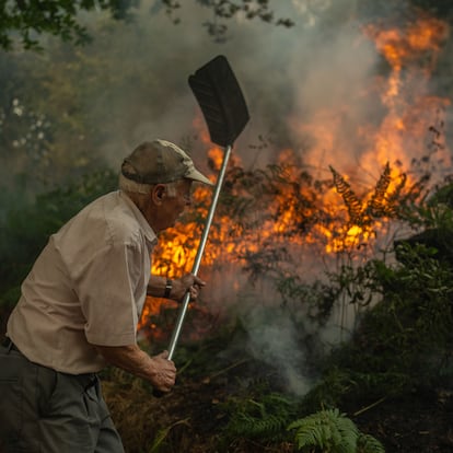 A Pobra de Trives (Ourense), 13/08/2025.- Un vecino de la aldea de Pareisás lucha contra en fuego en el incendio forestal que permanece activo en A Pobra de Trives (Ourense). EFE/Brais Lorenzo