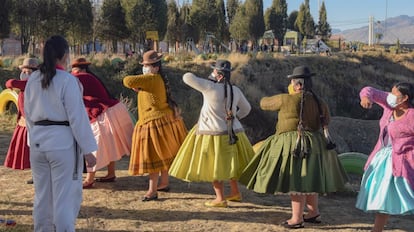 Un grupo de mujeres vestidas con pollera [en referencia a la falda tradicional que visten] aprende a utilizar los codos como defensa, bajo la mirada de la instructora Kimberly Nosa, en un taller realizado en el mirador Virgen Blanca, en El Alto.