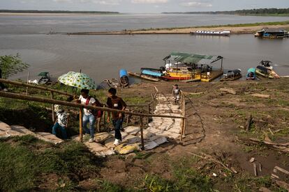 Varias personas suben del puerto provisional creado por el bajo nivel del agua, en Puerto Nariño.