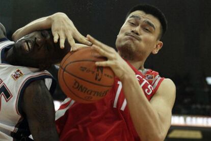 Yao Ming lucha por un rebote en un partido con los Houston Rockets.