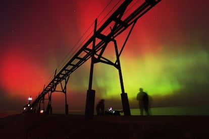 Aurora boreal ilumina el cielo nocturno frente al lago Michigan y el faro de St. Joseph, en Estados Unidos. 