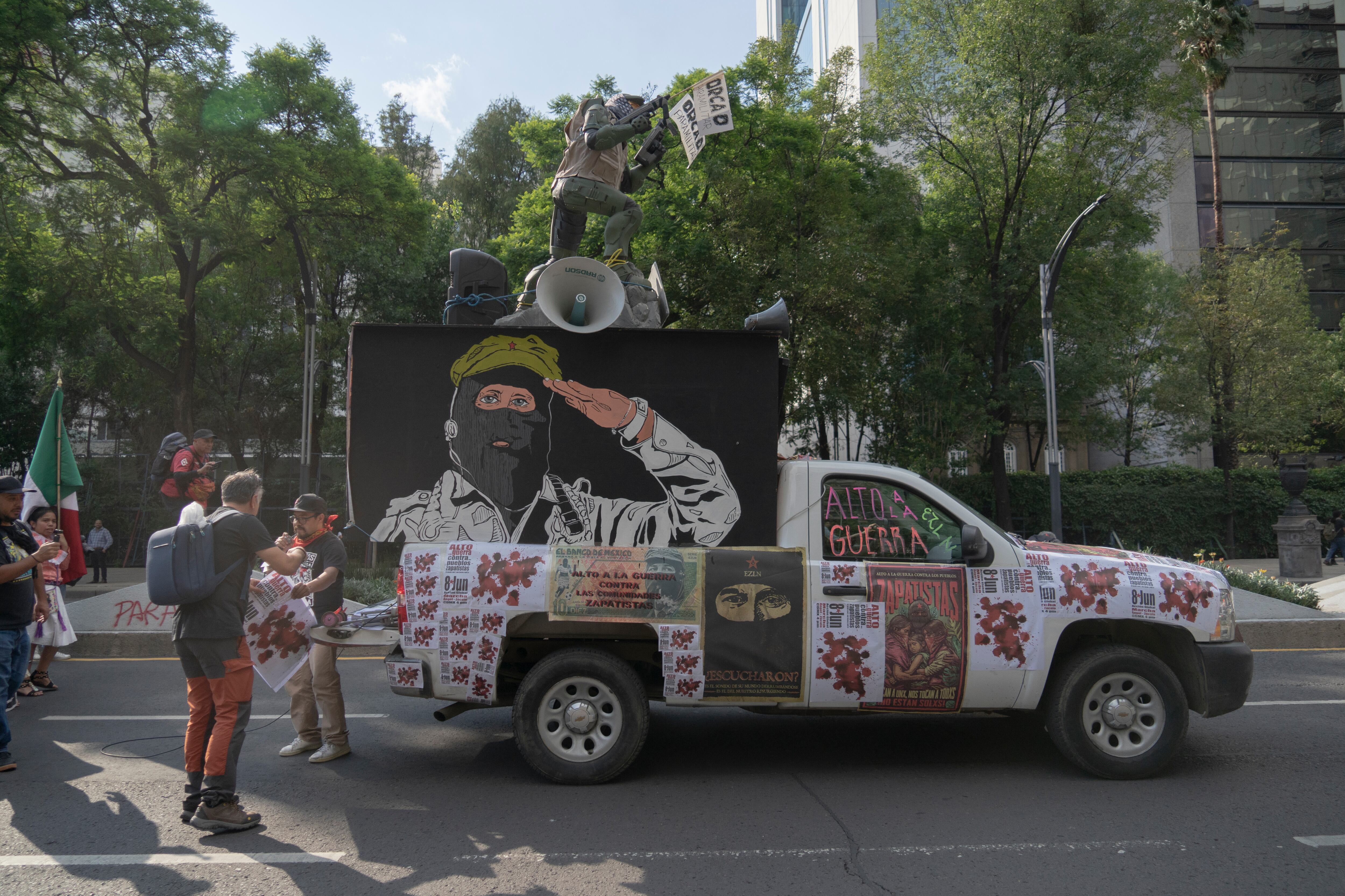 Una camioneta lleva una estatua militar con un letrero de la Orcao en el techo, a modo de denuncia del grupo paramilitar.