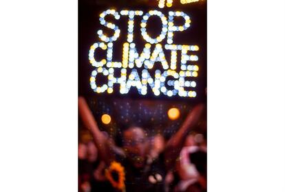 Adoptar medidas urgentes para combatir el cambio climático y sus efectos es una de las metas de los ODS. Durante una concentración nocturna frente al edificio de Naciones Unidas, en la plaza Dag Hammarskjold, un hombre levanta un emblema iluminado en el que se lee "Parad el cambio climático".