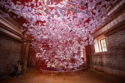 Dos visitantes contemplan la obra 'Tell Me Your Story' (cuéntame tu historia), una intervención del artista japonés Chiharu Shiota en el Gran Hammam de Pristina (Kosovo).