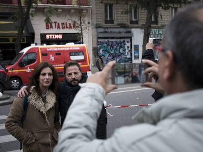 Una parella posa davant del Bataclan un any després de la matança de l'ISIS.