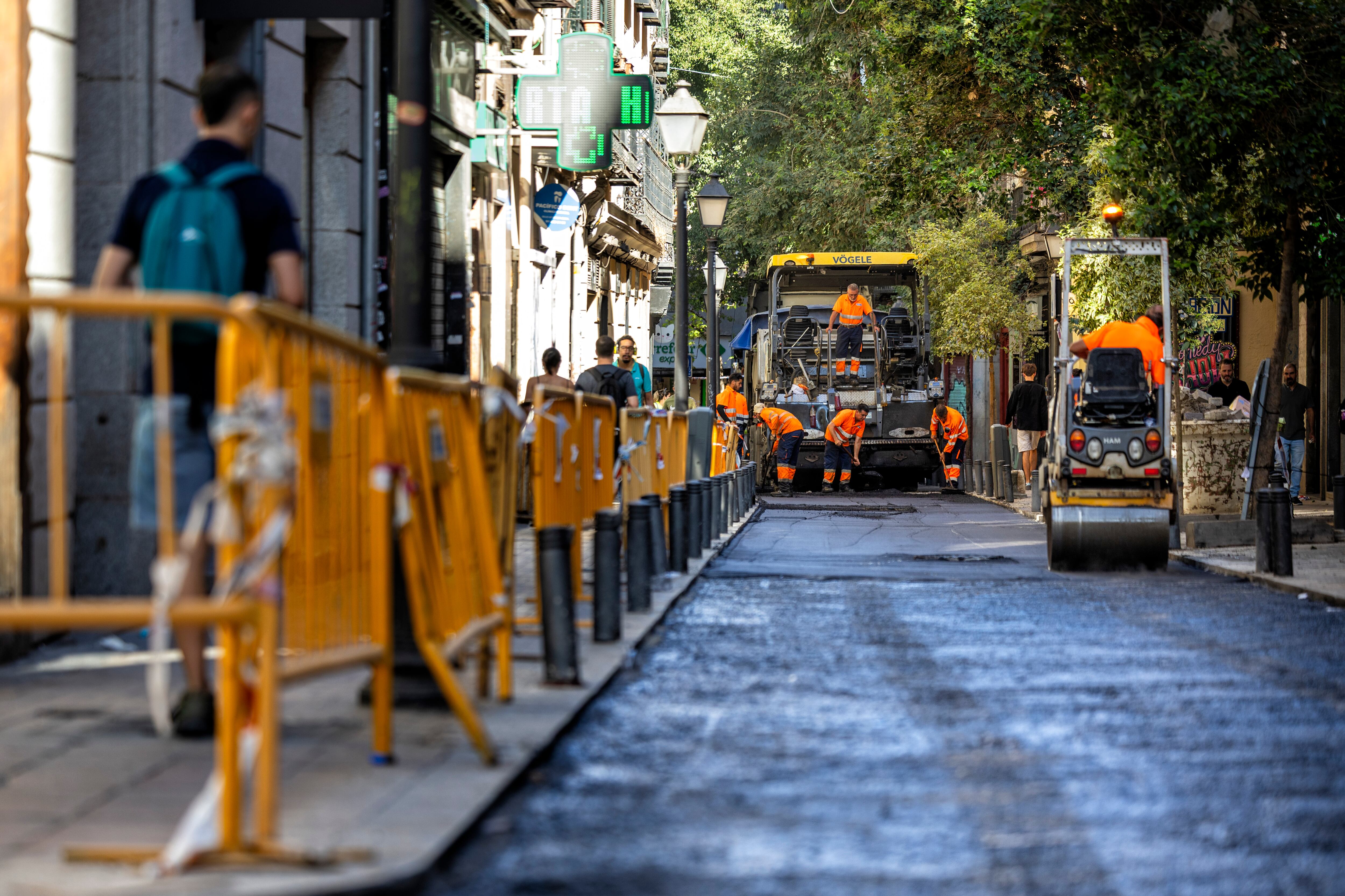 Un grupo de operarios trabajaban el pasado viernes 12 de septiembre en las obras de asfaltado de la calle del Pez, en el barrio de Malasaña (Madrid).