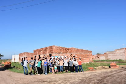 Familias seleccionadas para el proyecto 'Bienvenidos a mi pueblo' frente a las casas en construcción.