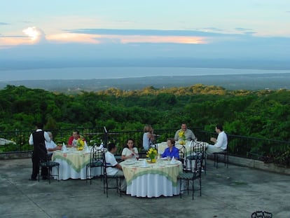 Un grupo de personas cena en el restaurante en la cima de Managua