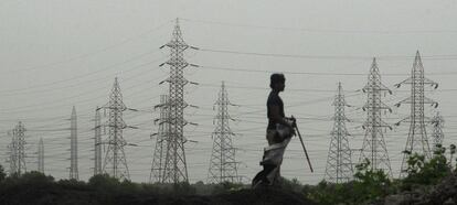 Un hombre observa unas torres de electricidad en Mumbai.