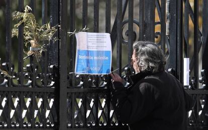 Un viandante mira un cartel que anuncia el cierre temporal del parque del Retiro en la puerta de Reina Mercedes, el 30 de septiembre de 2019.