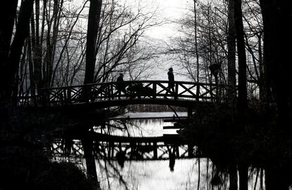 Una pareja camina sobre un puente del lago Grunewald en Berlín, Alemania.