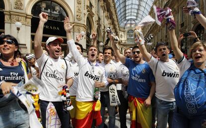 Aficionados con camisetas, bufandas y gorras del equipo blanco calientan motores antes del partido en la Galería Víctor Manuel II de Milán.