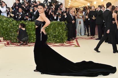 Kylie Jenner, fiel a su estilo, posó con minigafas, vestido negro de terciopelo y descalza (aunque con medias negras).