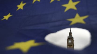 El Big Ben de Londres visto a trav&eacute;s de un agujero en una bandera de la Uni&oacute;n Europea.