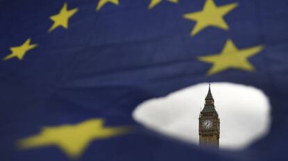 El Big Ben de Londres visto a través de un agujero en una bandera de la Unión Europea.