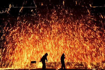 Varios artistas locales realizan la popular ducha de las chispas de hierro fundido durante un evento del Año Nuevo Lunar Chino en Anyang (China).