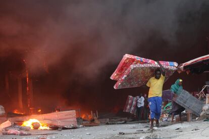 Un comerciante somalí trata de salvar algunas de sus mercancías del fuego, que se declaró en el mercado de Bakara, en Mogadiscio (Somalia).