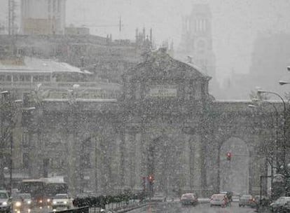 Vista de la Puerta de Alcalá durante la nevada caída ayer al mediodía en el centro de Madrid.