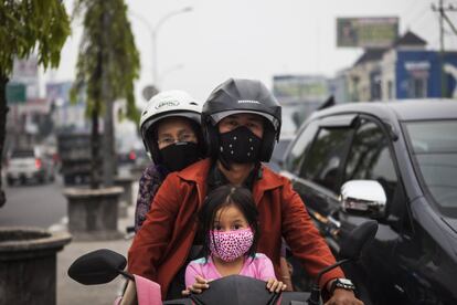 Un motorista en la ciudad de Pekan Baru acompañado de una mujer y una niña se protegen la cara con máscaras de la contaminación, Pekan Baru, Riau, Indonesia. La calidad del aire ha alcanzado niveles peligrosos por los incendios forestales que asolan la provincia de Riau en Indonesia. La niebla ha dejado a más de 22.000 residentes con problemas respiratorios.