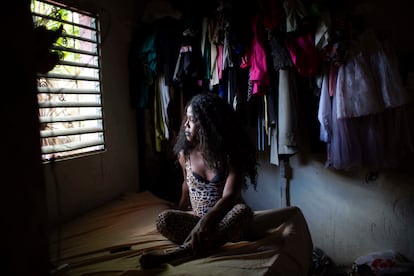 Geisha Collins Paul, trabajadora del sexo transexual de 39 años, mira por la ventana de su dormitorio en Santo Domingo, República Dominicana. Desde que empezó la pandemia dejó de trabajar con regularidad debido a las restricciones impuestas para frenar la covid-19.