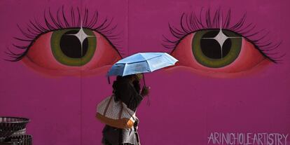 Una mujer pasa frente a un mural, en Los Ángeles (Estados Unidos).