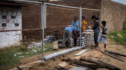 Miembros de la ONG La Papelera Tiene Hambre construían un muro con 'ecobloques' en la escuela Luz del Saber, en diciembre de 2022 en Maracaibo (Venezuela).