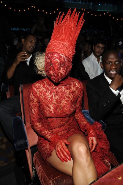 Lady Gaga acudió a los premios MTV con un vestido entero de encaje rojo que terminaba en su cabeza en forma de corona.