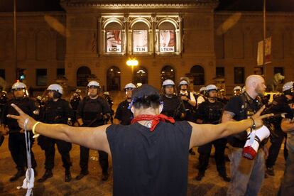 Un manifestante se encara con la polic&iacute;a desplegada frente al Instituto de arte, donde la primera dama Michelle Obama da una cena a los consortes de los mandatarios de la OTAN.