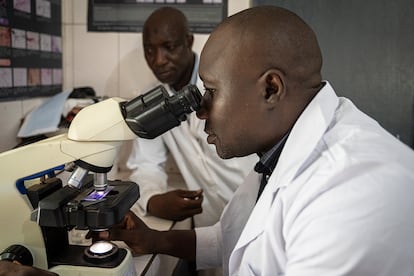 El biólogo Fakouma Camara examina la muestra de sangre de un paciente bajo el microscopio. Así se detecta si hay parásitos responsables de la malaria en la sangre. Gracias al apoyo de USAID, Fakouma ha formado a decenas de biólogos y técnicos de laboratorio para analizar los resultados de los pacientes con malaria en los distintos centros de salud del país.