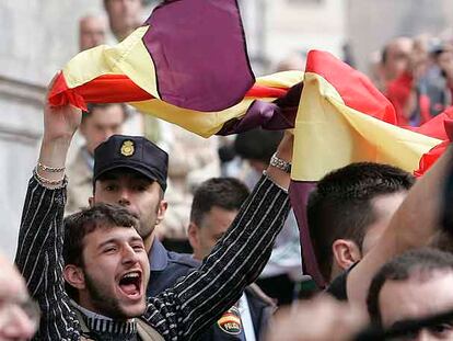 Un joven despliega una bandera republicana en protesta por la presencia de los Reyes en Oviedo.