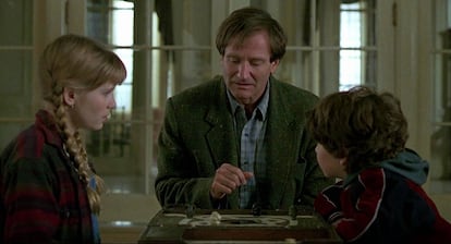 Kirsten Dunst, Robin Williams y Bradley Pierce en la película 'Jumanji' (1995) entretenidos con un juego de rol.