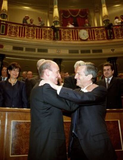 Miquel Roca y Adolfo Su&aacute;rez se saludan en un acto en el Congreso en 2001. 