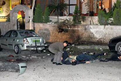 Un hombre inspecciona cadáveres de víctimas que yacen frente al hotel Days Inn, en Ammán.