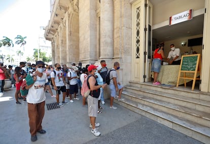 Ciudadanos hacen fila para comprar en una cafetería este sábado, en La Habana (Cuba).