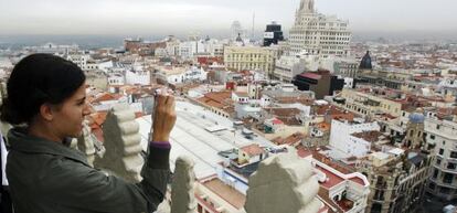 Una mujer fotografía los tejados de Madrid desde la terraza del hotel Petit Palace Alcalá, una de las empresas afectadas.